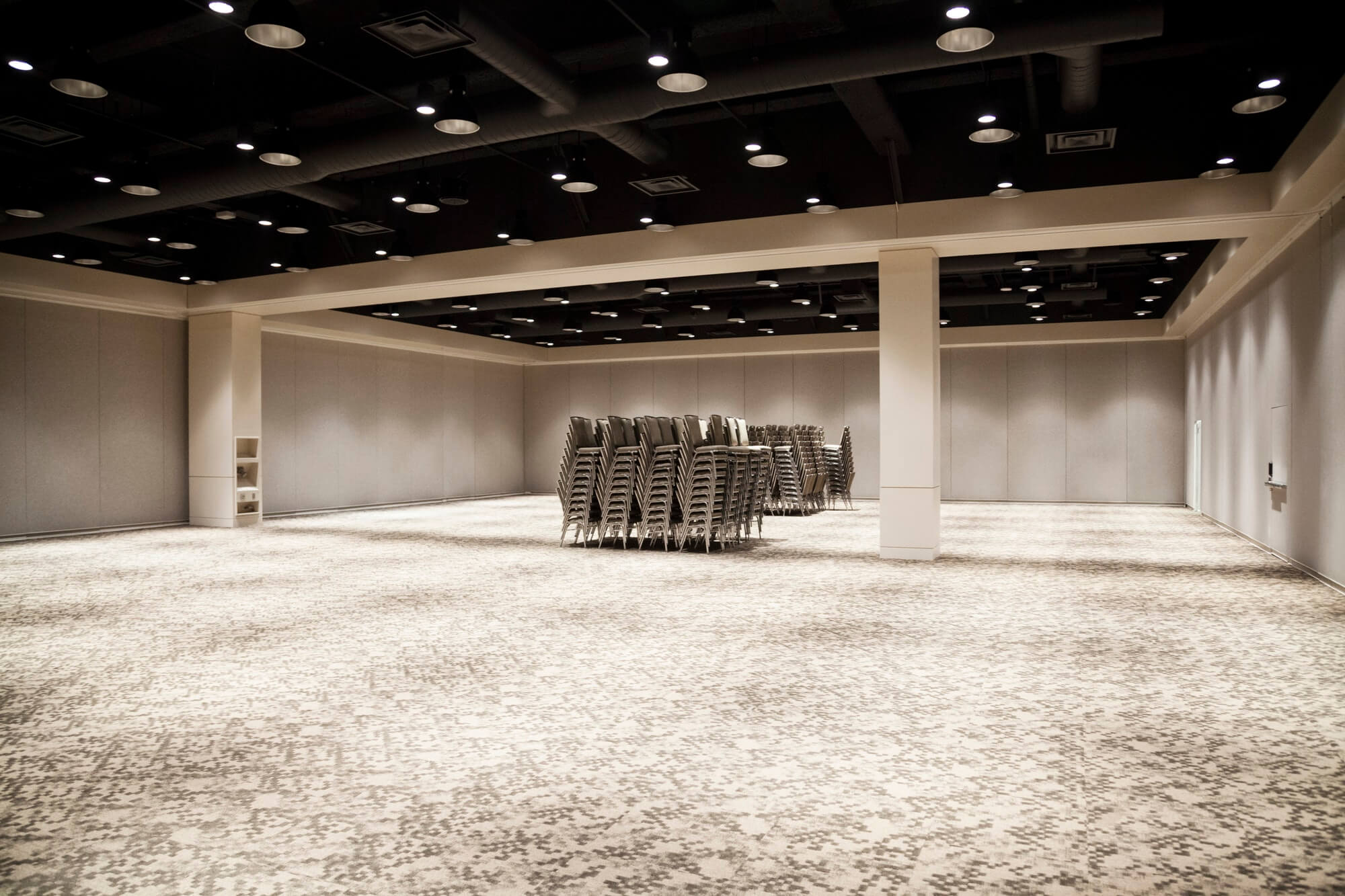 Stacked chairs in an empty convention center meeting room.